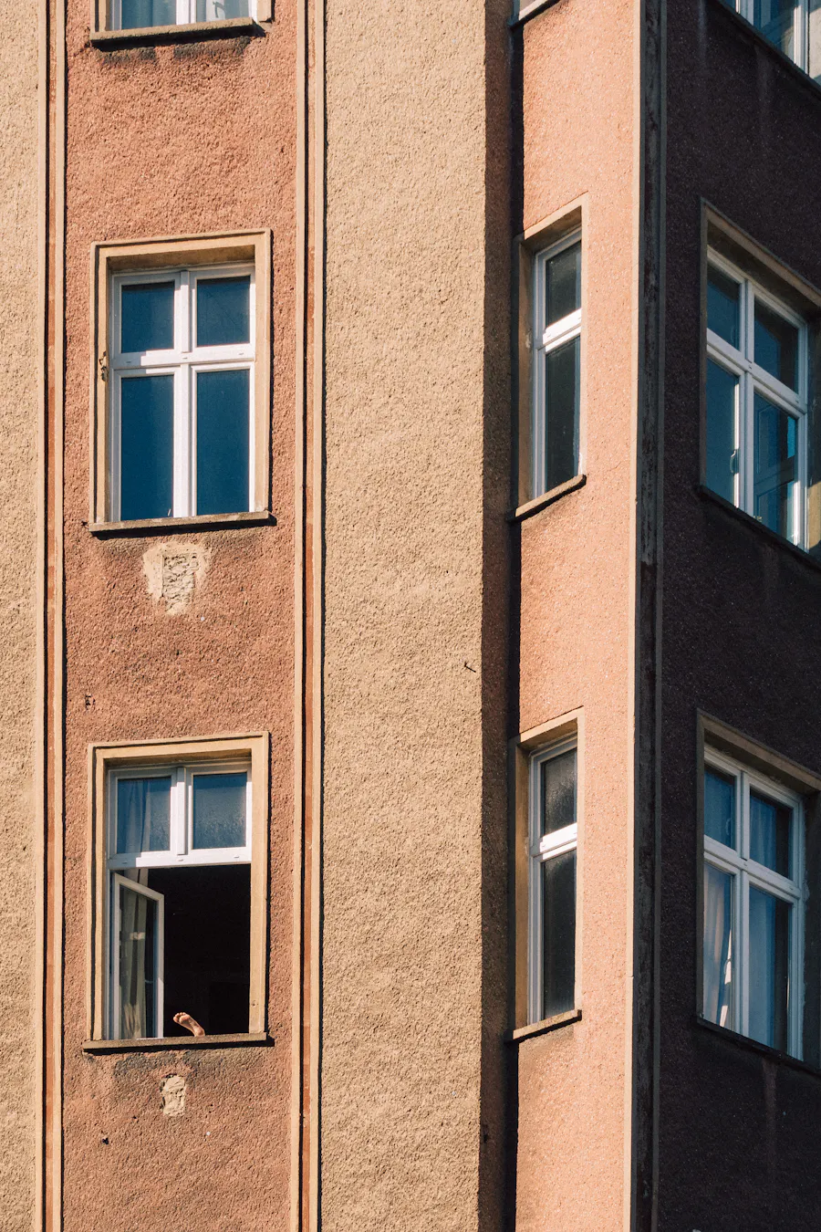 Detail einer Berliner Altbaufassade mit Putzflächen und hohen Fenstern